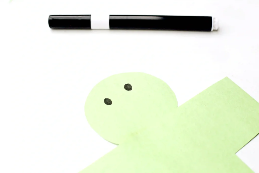 Letter I Iguana Craft - Cultivating Brilliant Minds Marker pen lying horizontally on a white background, with pale green shapes visible in the lower right area.