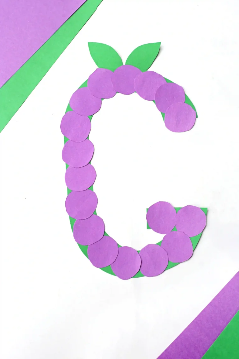 a letter g craft for preschoolers of a construction paper g with purple circles to represent grapes