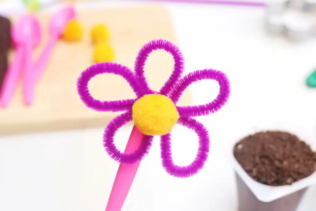 Flower Pot Parfait Cups - Cultivating Brilliant Minds a pipe cleaner flower attached to a spoon
