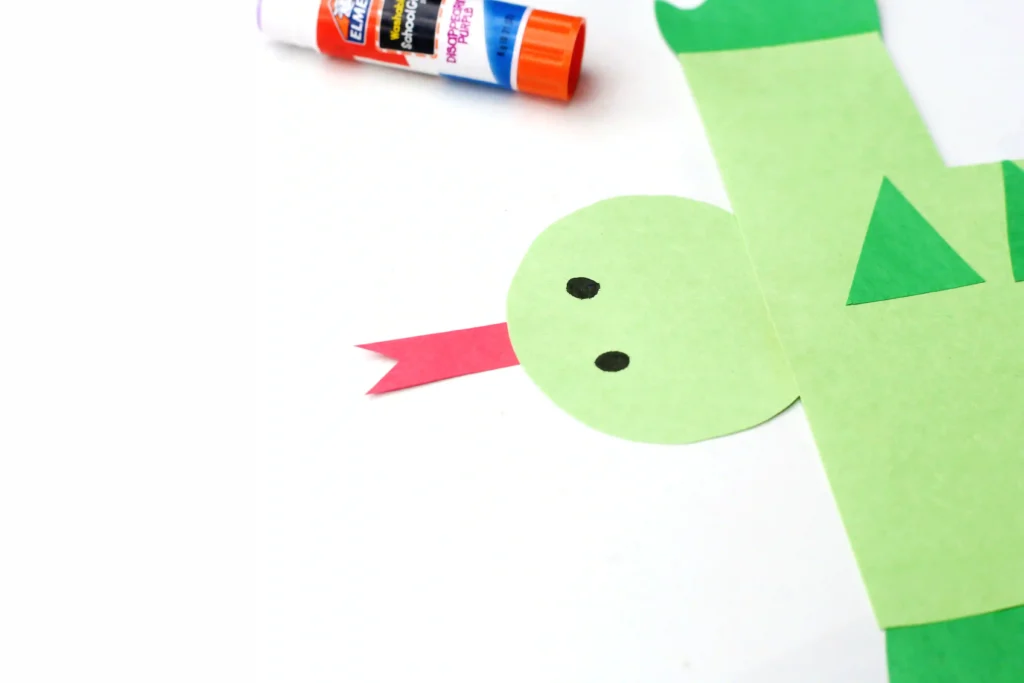 Letter I Iguana Craft - Cultivating Brilliant Minds an iguana head cut out of green construction paper with eyes and a red tongue