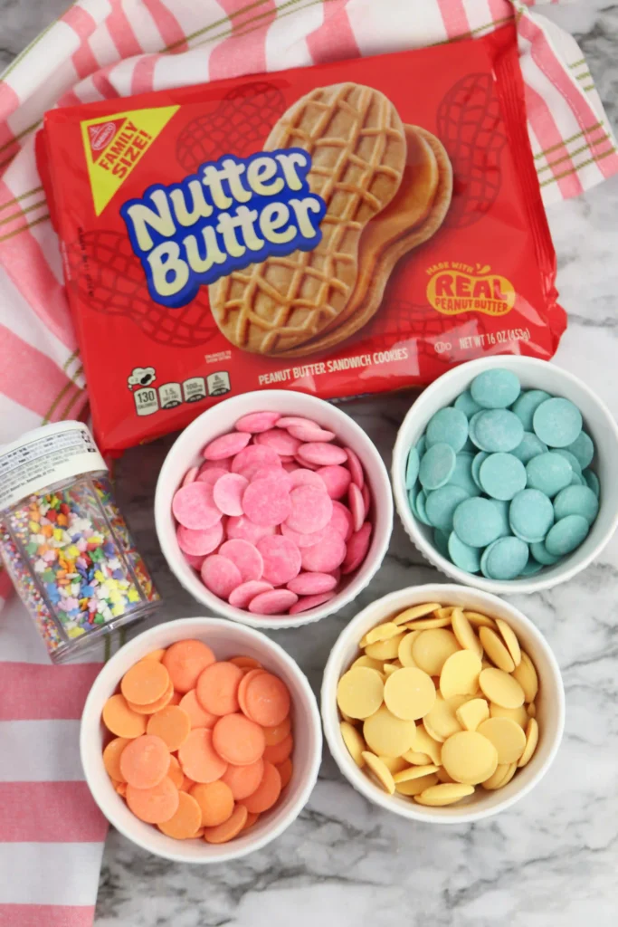 Flip Flop Cookies - Cultivating Brilliant Minds Red bag of Nutter Butter peanut butter sandwich cookies with bowls of pastel candy melts nearby.