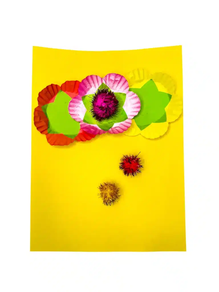 Cupcake Liner Flower Craft - Cultivating Brilliant Minds cupcake liners glued on yellow construction paper with pom poms glued inside