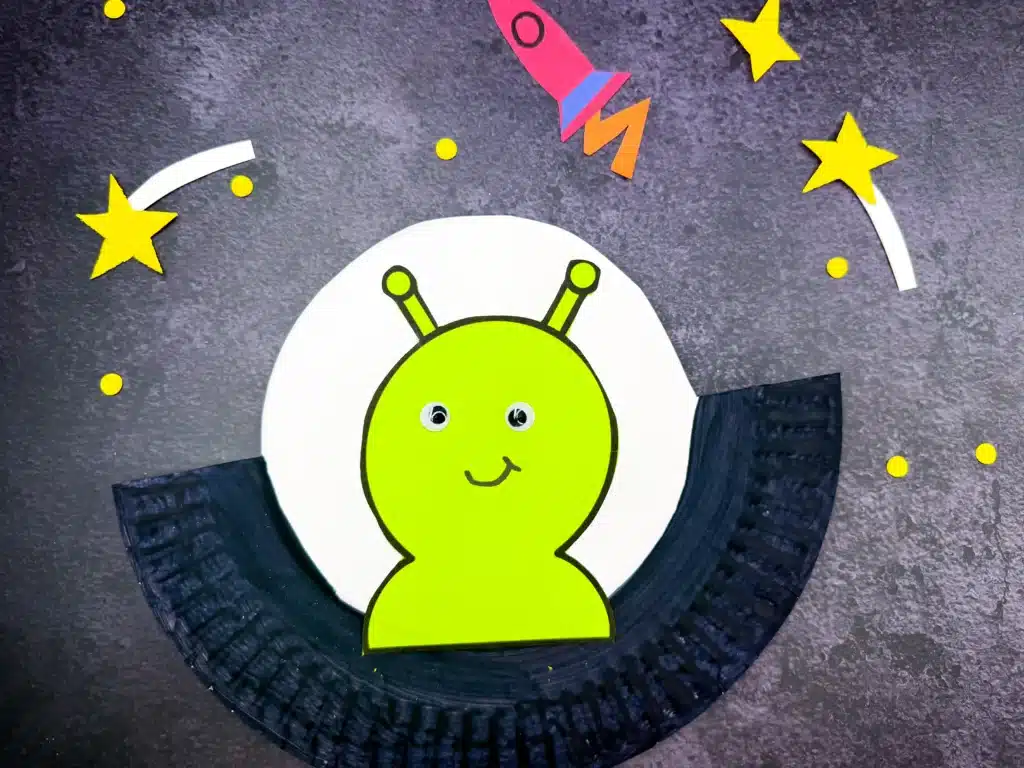 UFO Paper Plate Craft - Cultivating Brilliant Minds a paper plate cut and painted to look like a UFO with an alien inside