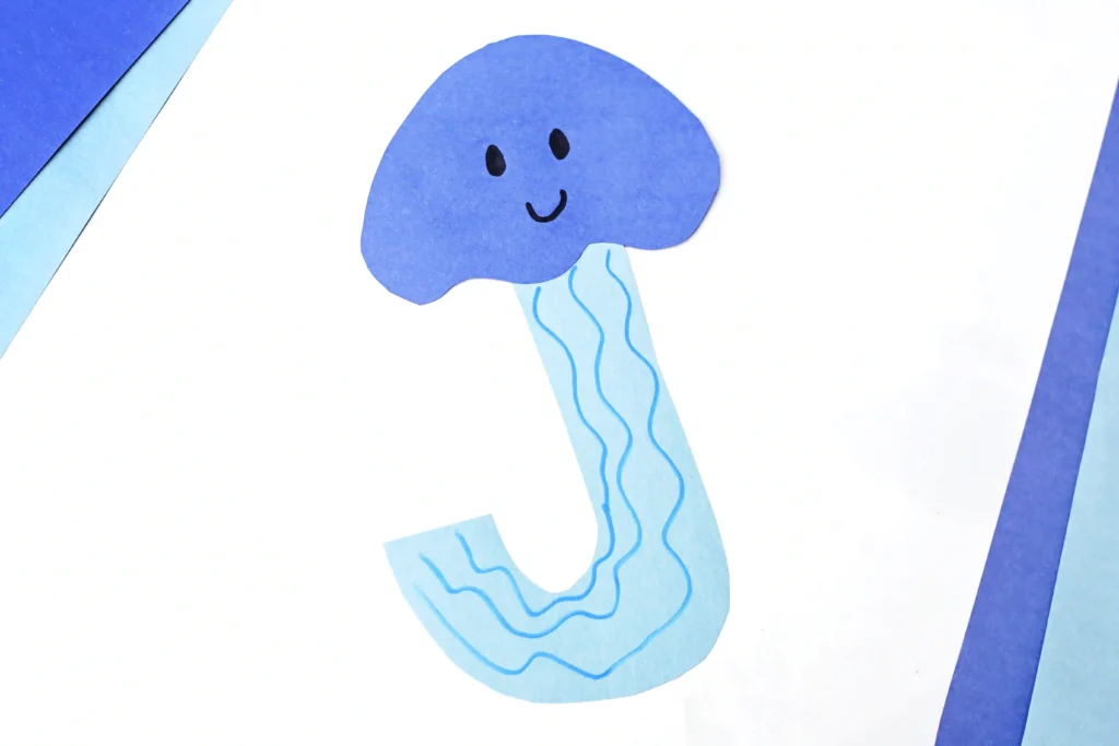 Letter J Jellyfish Craft - Cultivating Brilliant Minds a letter j craft cut out of blue construction paper to look like a jellyfish