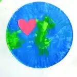 No-Mess Earth Day Painting - Cultivating Brilliant Minds a paper plate painted with green and blue paint to look like an Earth with a red construction paper heart