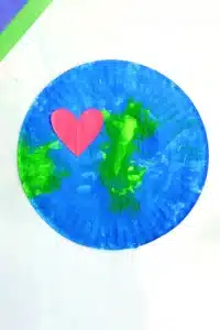 a paper plate painted with green and blue paint to look like an Earth with a red construction paper heart