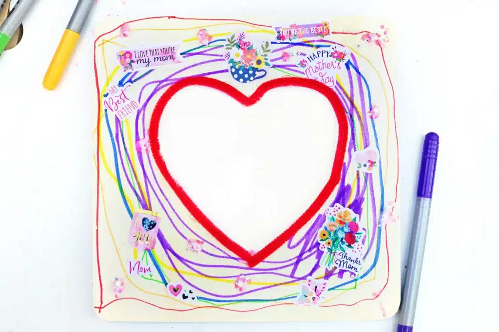 Picture Frame Decorating Tray - Cultivating Brilliant Minds a square wooden picture frame with a heart in the middle decorated with stickers and markers