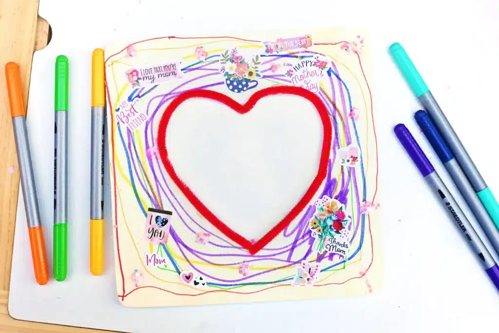 Picture Frame Decorating Tray - Cultivating Brilliant Minds a square wooden picture frame with a heart in the middle decorated with stickers and markers