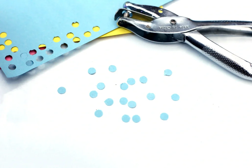 Letter D Craft - Cultivating Brilliant Minds blue construction paper punched into holes with a hole puncher