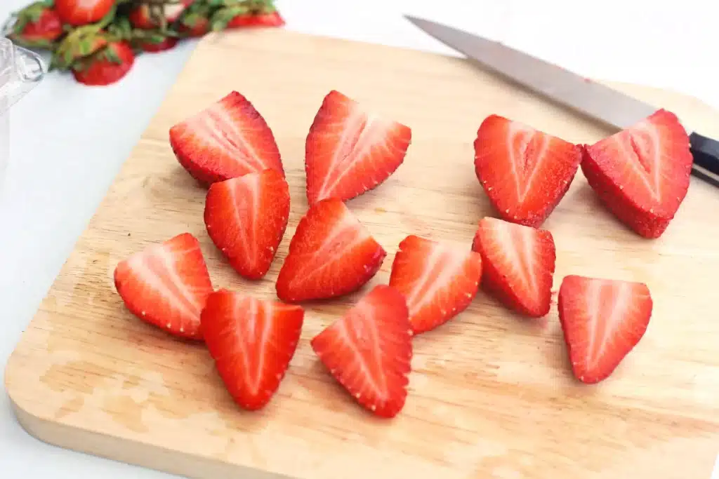 Deviled Strawberries - Cultivating Brilliant Minds sliced strawberries on a wooden cutting board