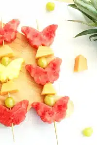 spring fruit kabobs on a wooden cutting board