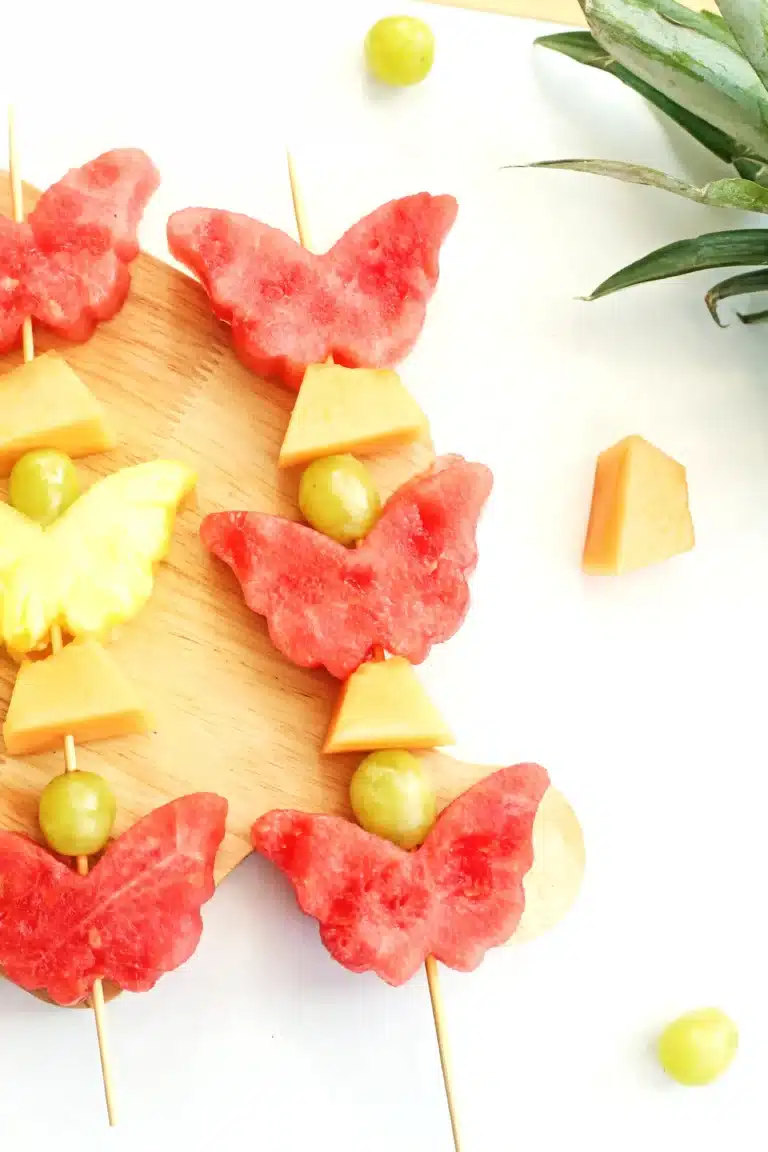 spring fruit kabobs on a wooden cutting board