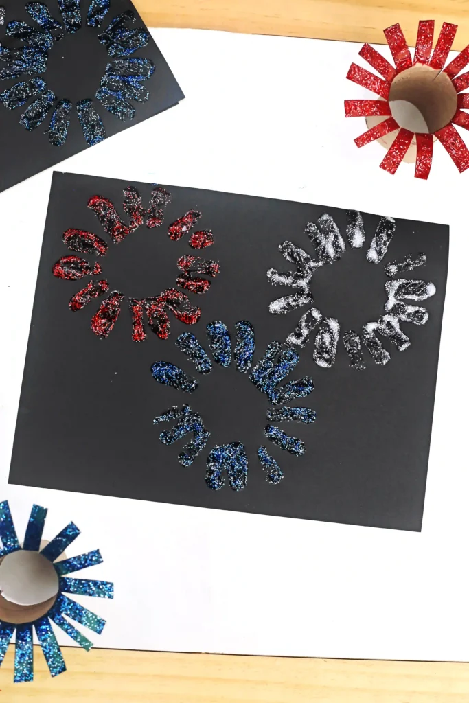 Toilet Paper Roll Firework Craft - Cultivating Brilliant Minds a black paper with glitter paint fireworks stamped on
