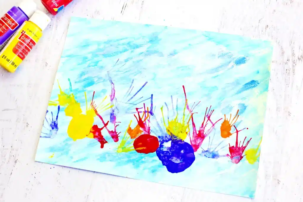 Coral Blow Painting With Straws - Cultivating Brilliant Minds a coral blow painting with straws that has a watercolor background and coral made by blowing paint through a straw