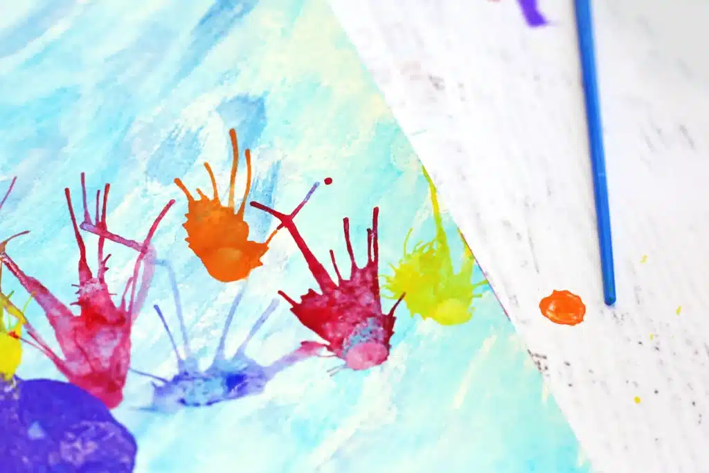 Coral Blow Painting With Straws - Cultivating Brilliant Minds a coral blow painting with straws that has a watercolor background and coral made by blowing paint through a straw