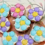 Vanilla Wafer Flower Cookies - Cultivating Brilliant Minds a vanilla wafer with icing and pastel m&ms in the shape of a flower