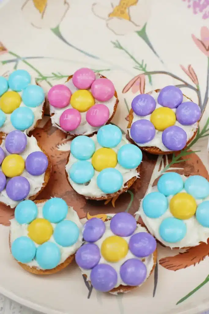 Vanilla Wafer Flower Cookies - Cultivating Brilliant Minds a vanilla wafer with icing and pastel m&ms in the shape of a flower