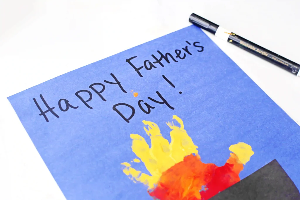 Father's Day Handprint Craft - Cultivating Brilliant Minds a red orange and yellow handprint on blue construction paper that reads "happy father's day!"