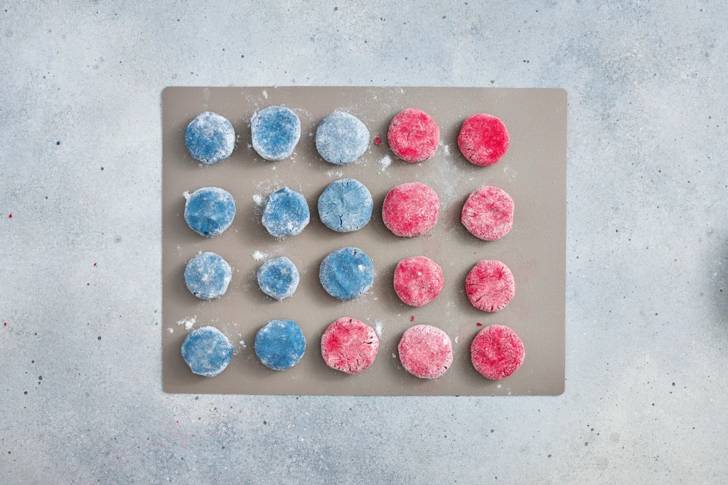 red and blue crinkle cookies on a baking sheet