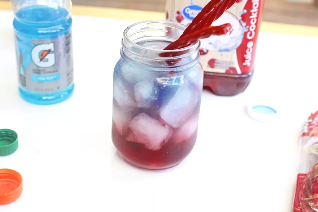 a patriotic red, white, and blue drink with ice and twizzlers