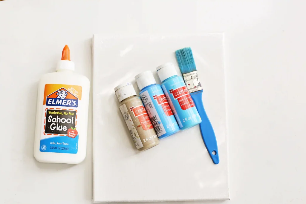 a cancas, glue, blue paint in 2 shapes, tan paint, and a paintbrush