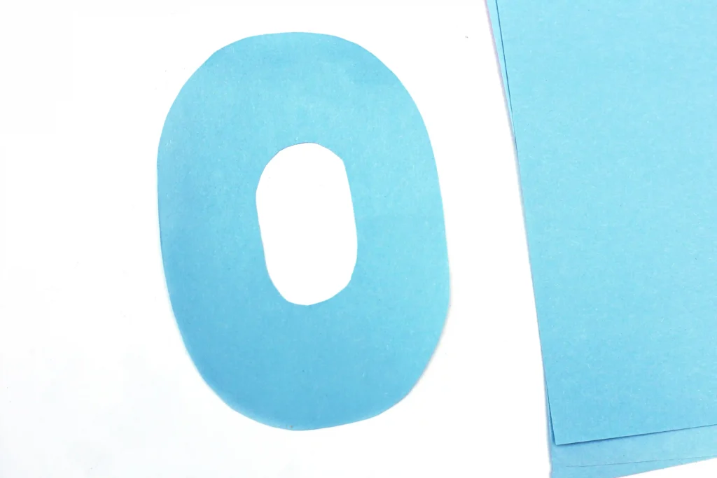 Close-up of a blue letter O on a white page with blue sticky notes on the right side.