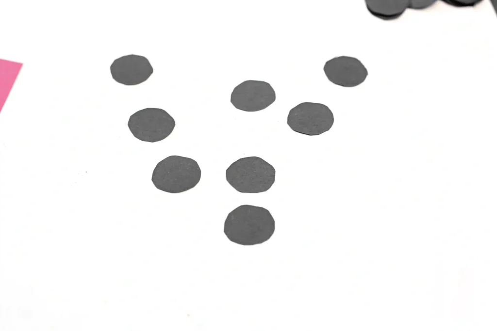 Loose cluster of gray circular dots scattered on a white background, with a hint of pink at the edge.