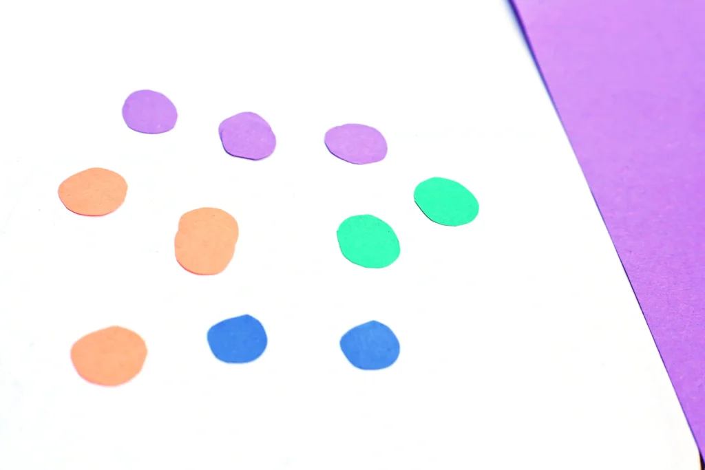 Letter Q Queen Craft - Cultivating Brilliant Minds circles cut out of blue, green, purple, and orange construction paper