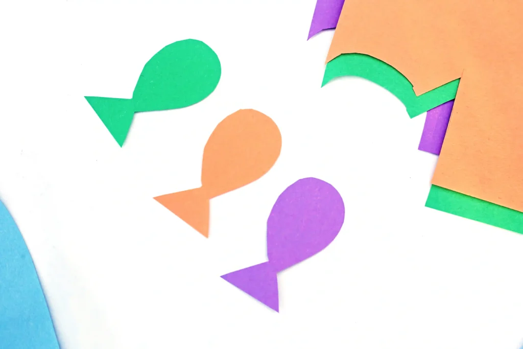 green, orange, and purple fish cut out of construction paper