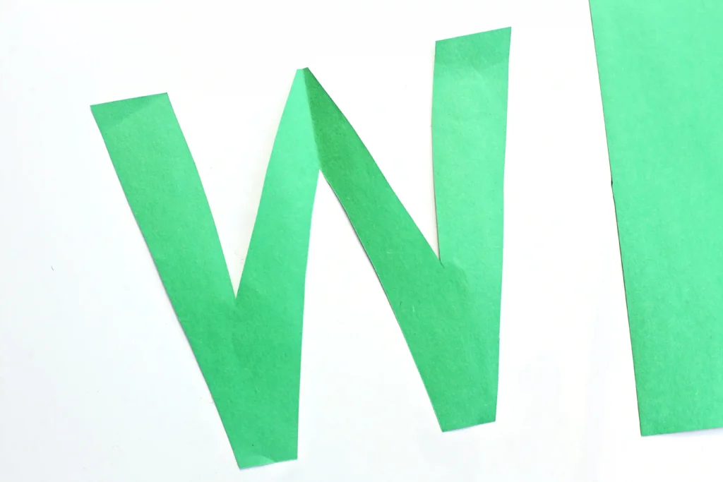 a letter w cut out of green construction