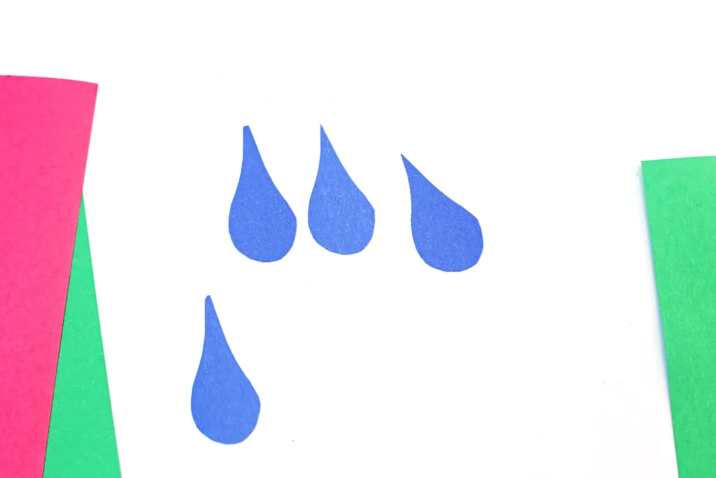 Abstract composition with three blue teardrop shapes on a white background, framed by pink (left) and green (right) border strips.