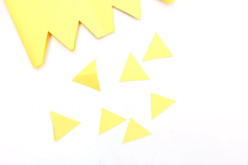 Several small yellow paper triangles scattered on a white background.