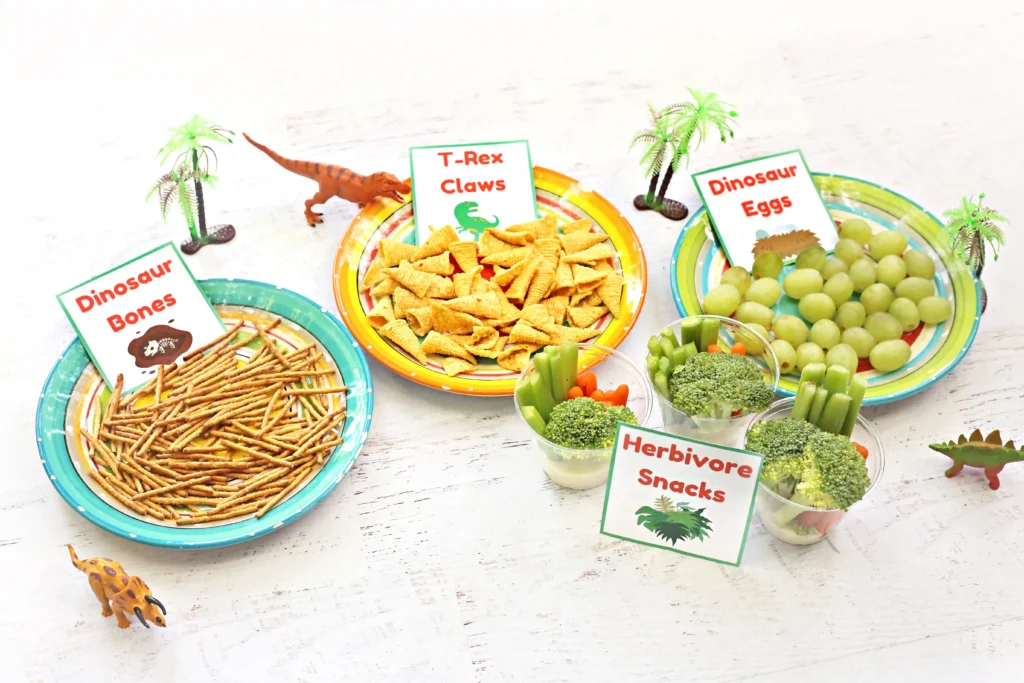 dinosaur party food labels with grapes, pretzels, bugles, broccoli, and carrots