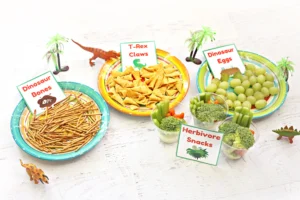 dinosaur party food labels with grapes, pretzels, bugles, broccoli, and carrots