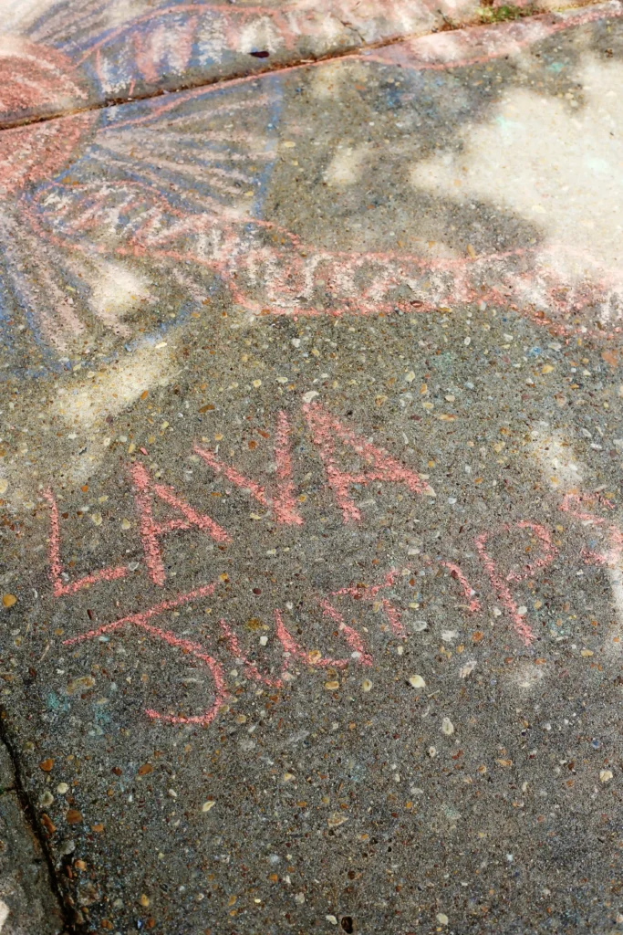 chalk on the sidewalk that reads lava jump