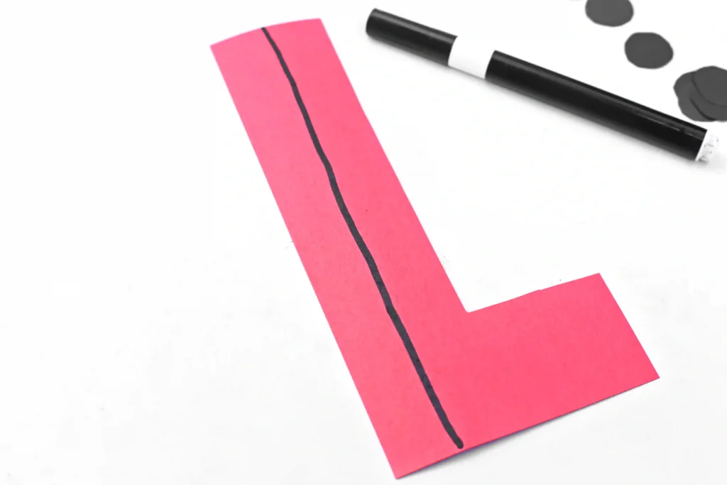 a red letter l cut out of construction paper with a black line draw on it