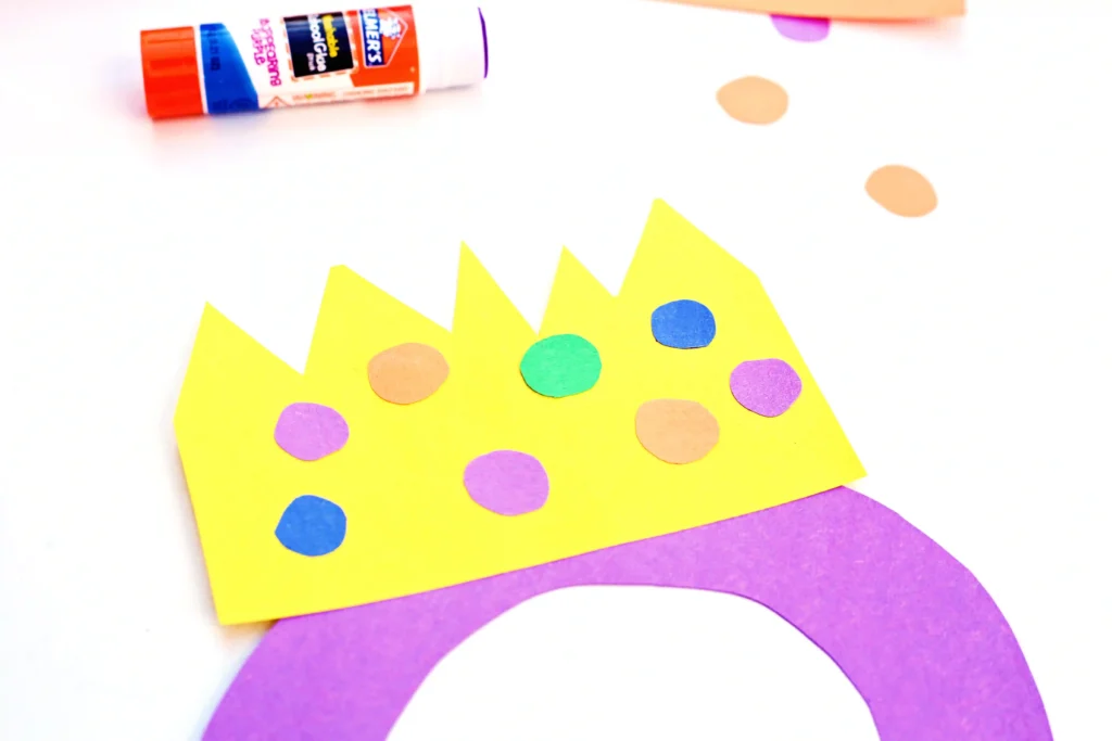 Letter Q Queen Craft - Cultivating Brilliant Minds a letter q cut out of purple construction paper with a construction paper crown on top
