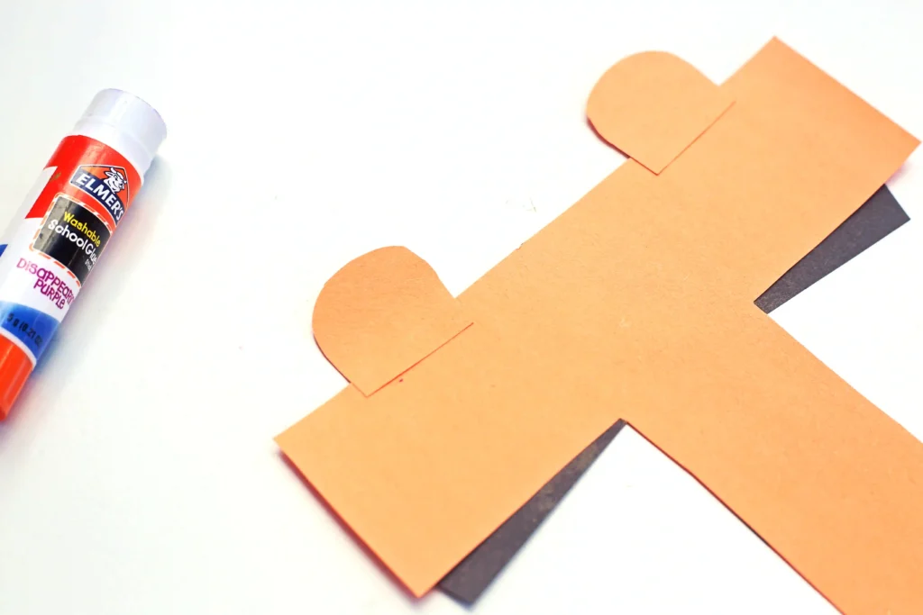 An uppercase T activity with the letter t cut out of orange construction paper with ears