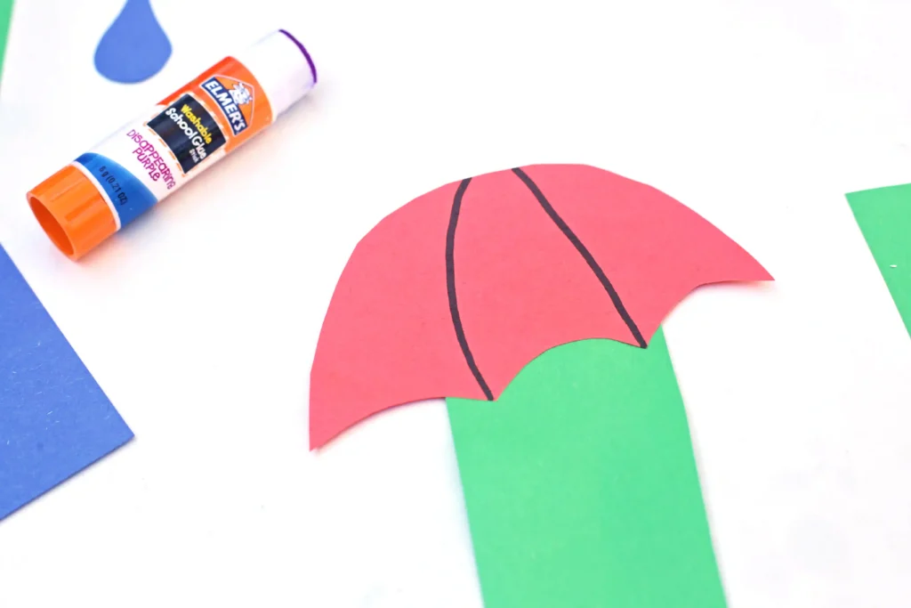 a letter craft for preschoolers that has a green letter u cut out of construction paper with a red umbrella top glued on