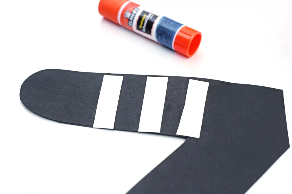 a black letter z cut out of construction paper with white paper strips glued on to look like a zebra for this zoo craft