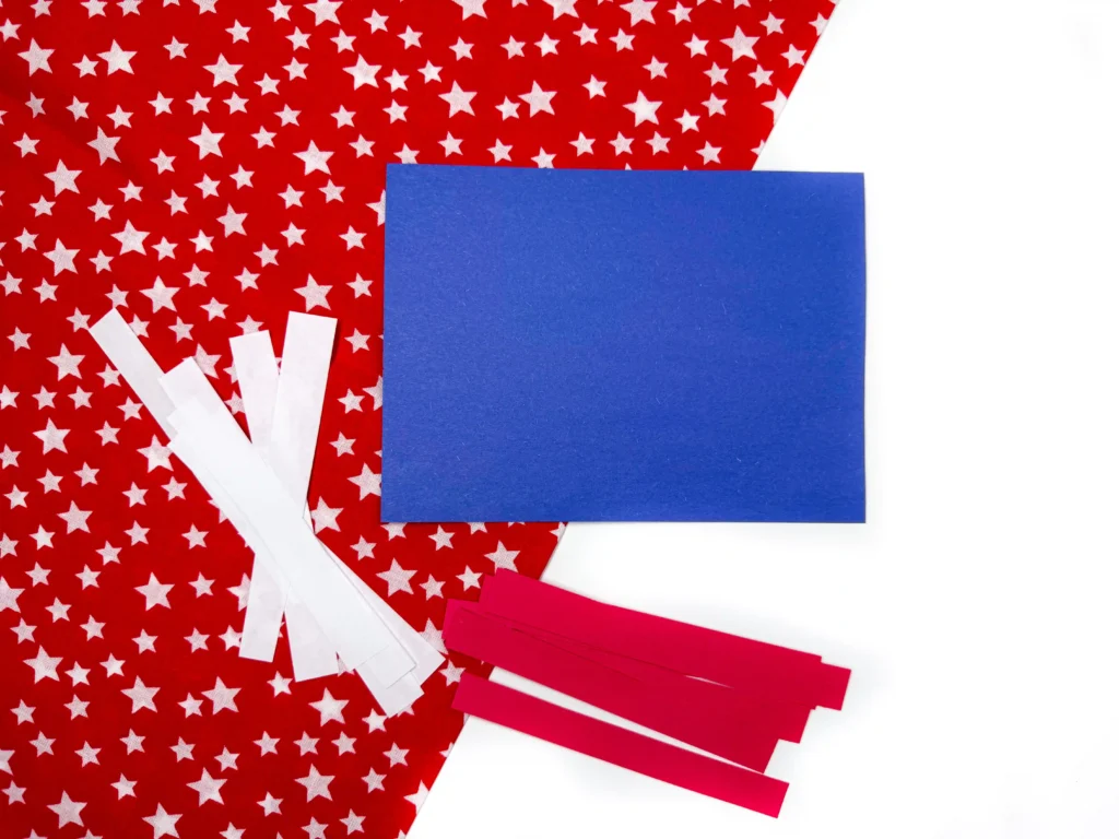 Patriotic craft collage: red star-patterned paper with a blue square and white strips.