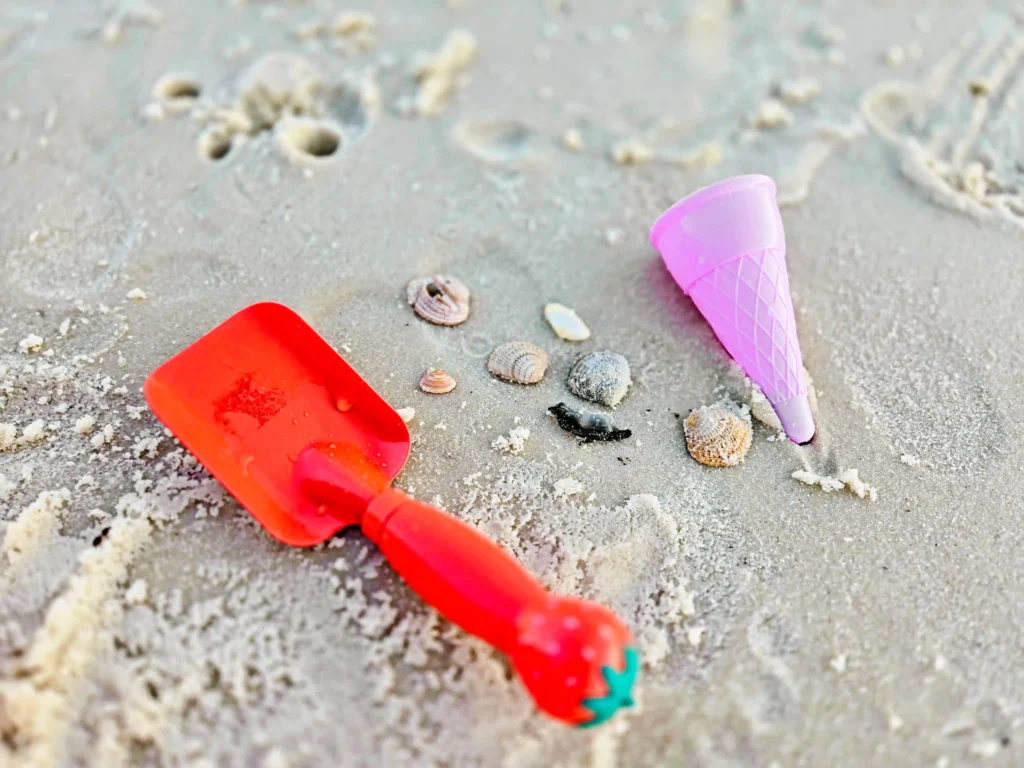 sand shovel, plastic ice cream cone, and seashells on the beach for an Ice Cream Sand Activity