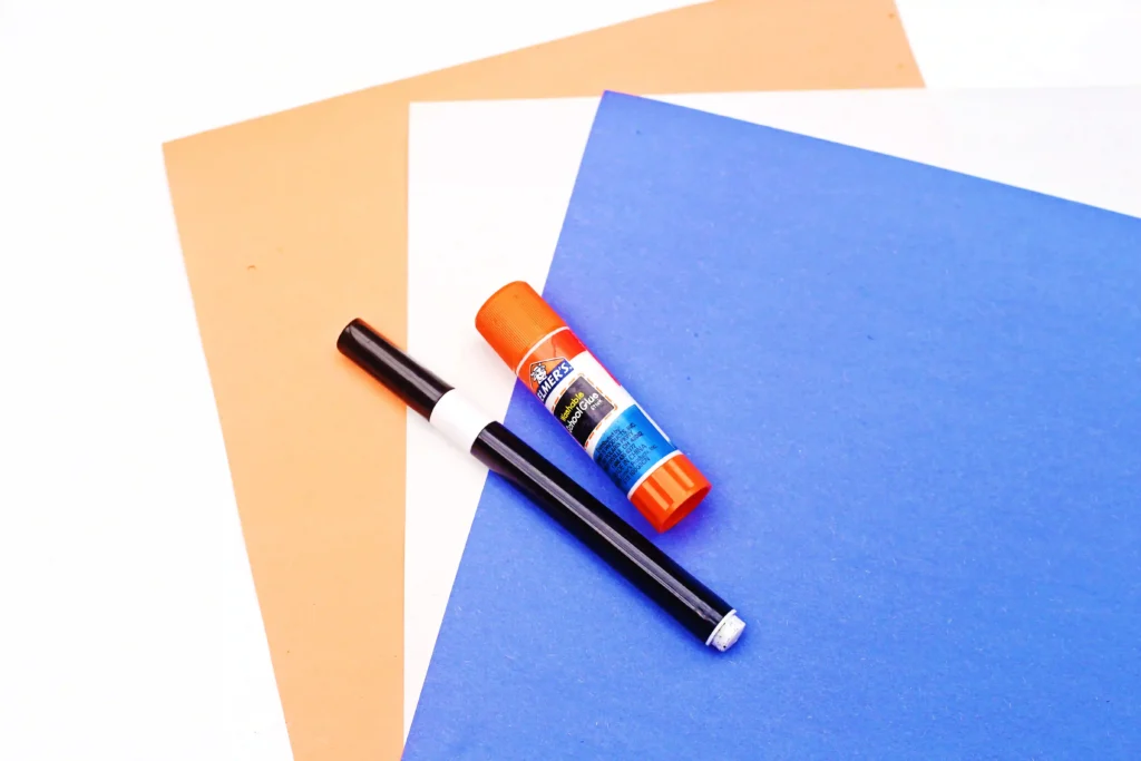 colored construction paper, a black marker, and a glue stick- the supplies for the k is for kite paper craft alphabet activity