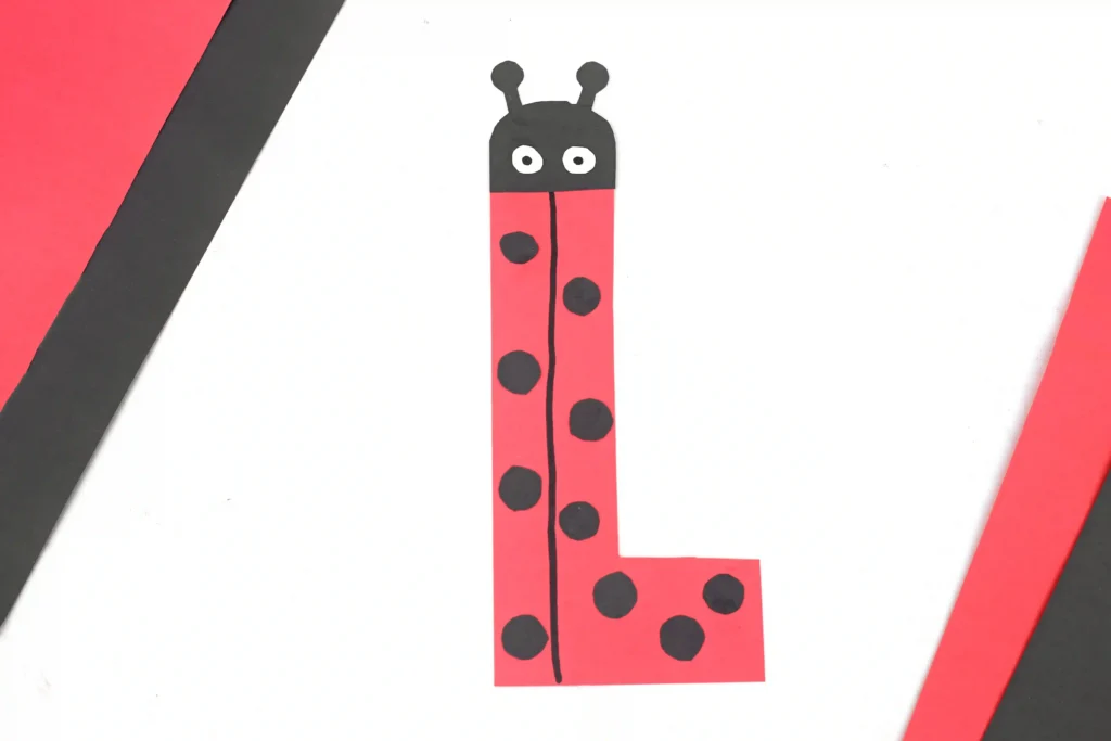 construction paper cut to look like the letter l and decorated like a ladybug