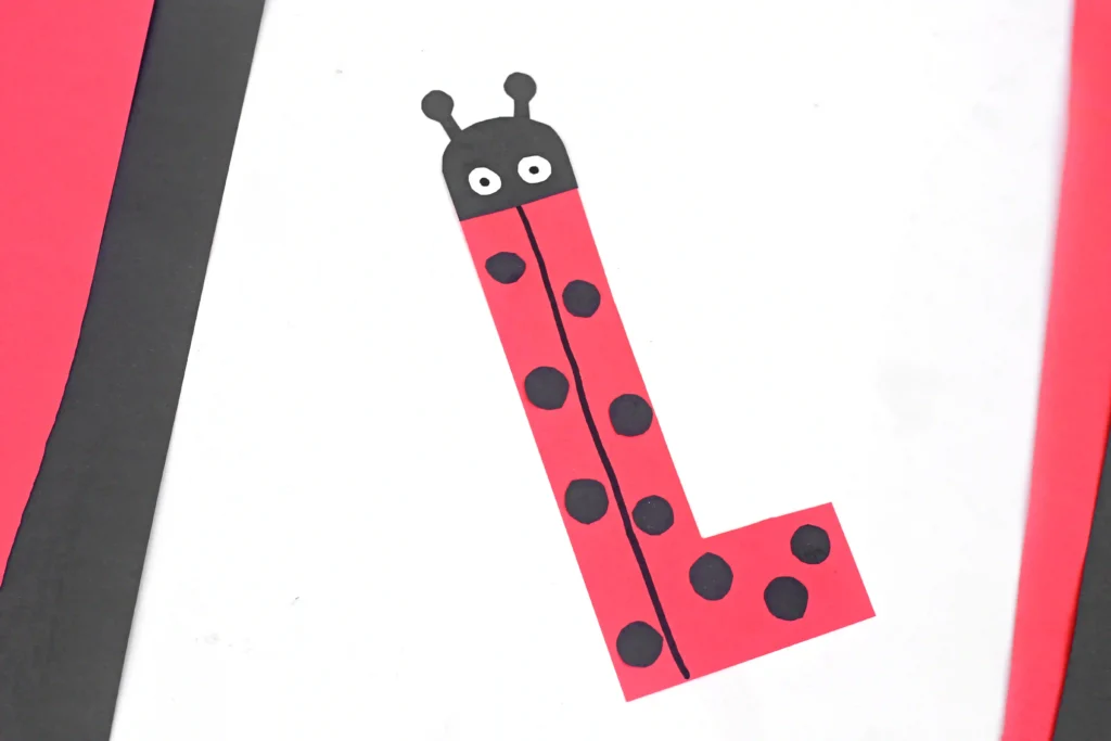 construction paper cut to look like the letter l and decorated like a ladybug