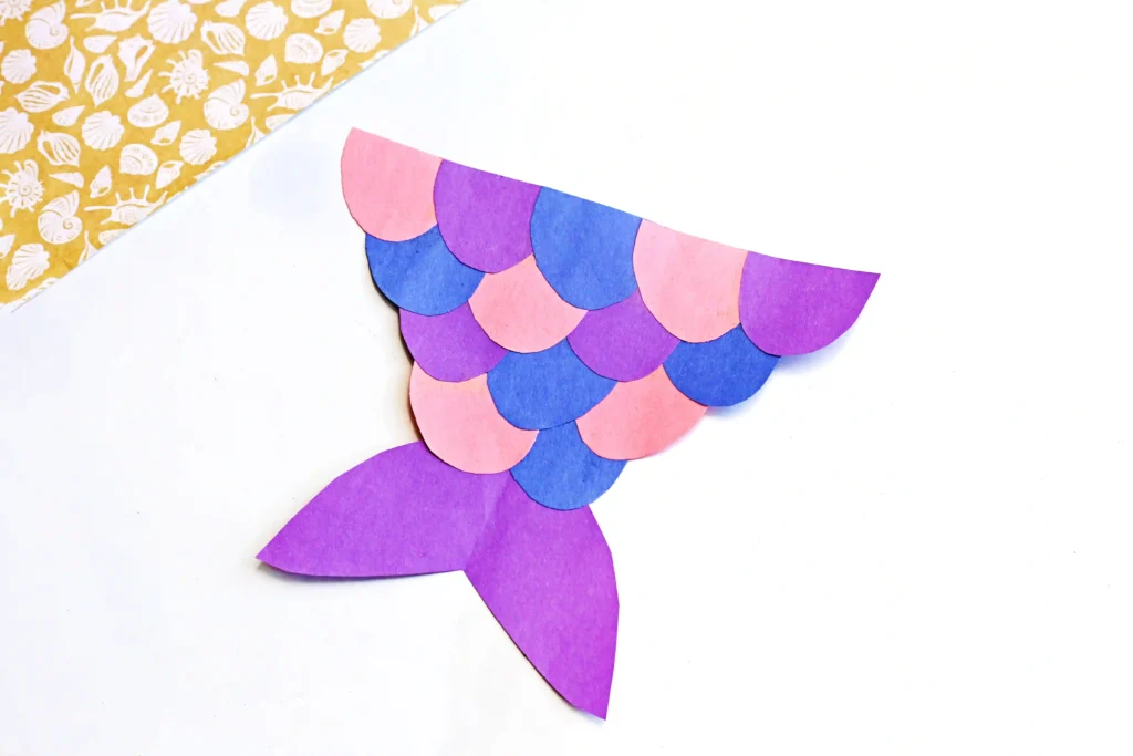 a mermaid tail craft made out of pink, purple, and blue construction paper