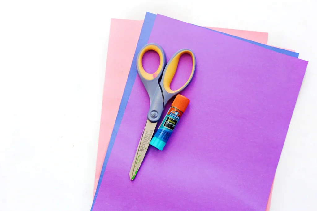 pink, blue, and purple construction paper, scissors, and a glue stick