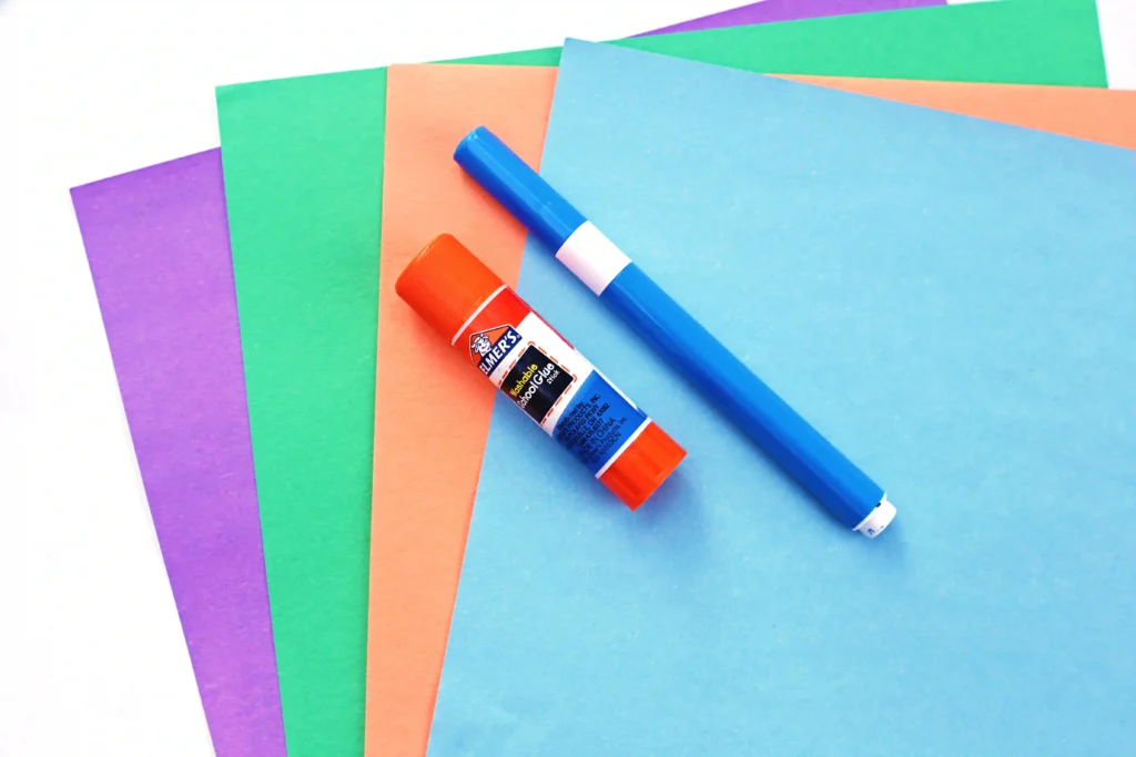 supplies for the letter o ocean craft- purple, green, orange, and blue construction paper, a blue marker, and a glue stick