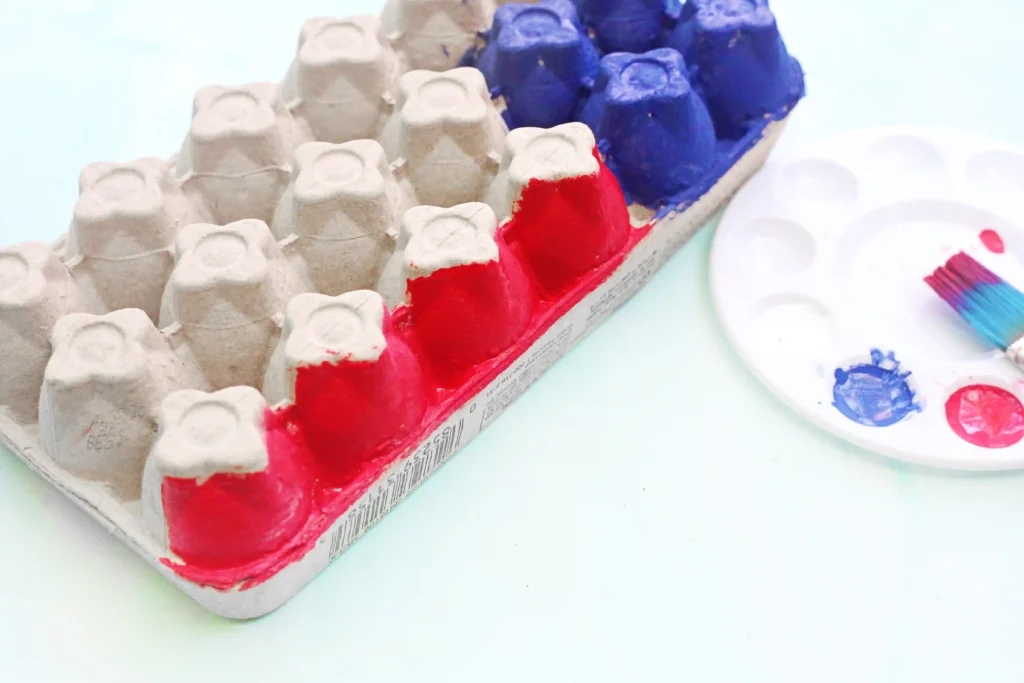 Close-up of an egg carton with red and blue paint 