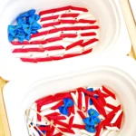 Assorted tricolor pasta (red and white tubes) with blue bow-tie pasta in a white container next to a container with the pasta arranged as an american flag